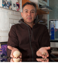 El doctor Roberto Arreguín Espinosa, miembro de la Academia Mexicana de Ciencias, con dos tipos de caracoles que se estudian en su laboratorio.